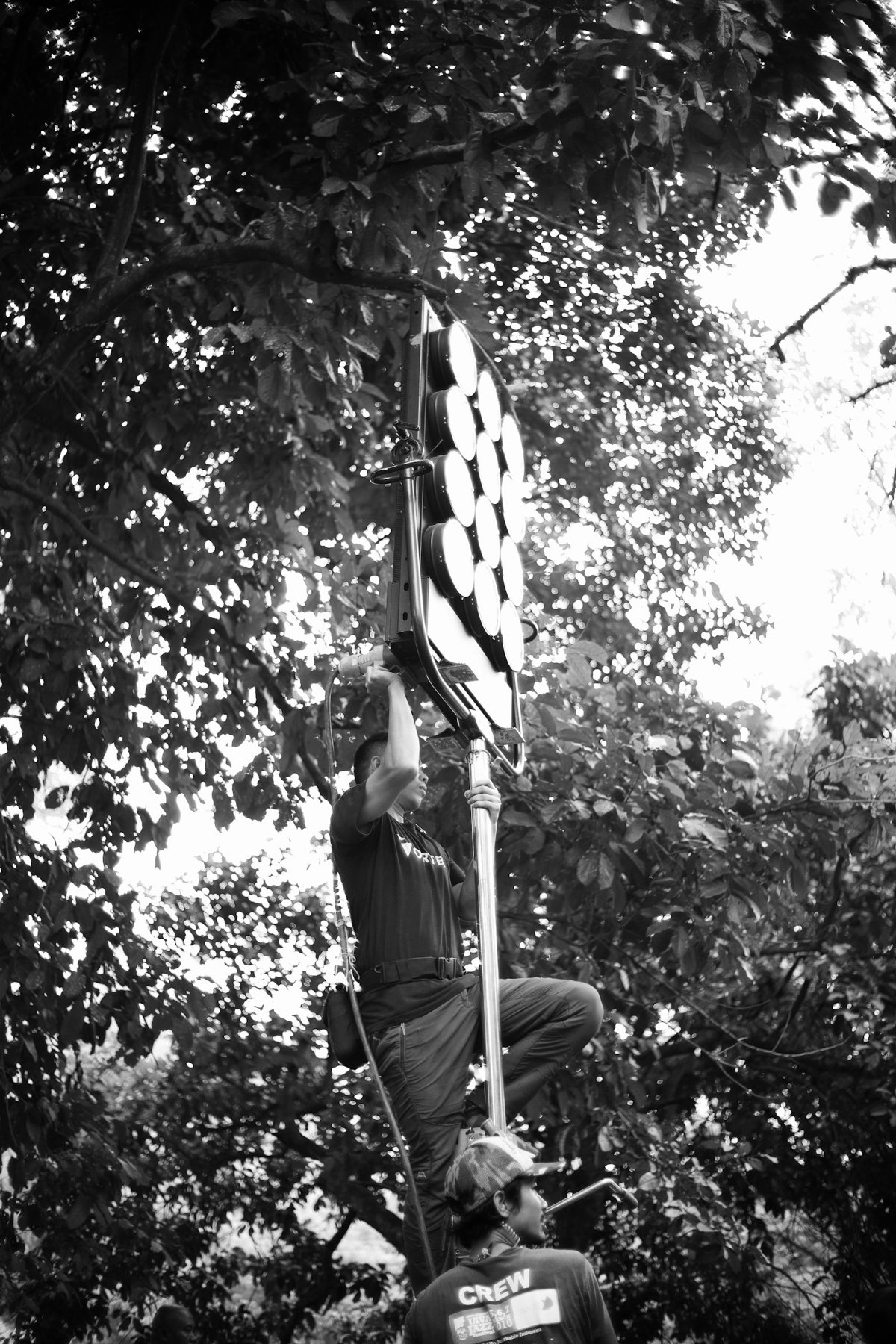 Crew member rigging a light fixture