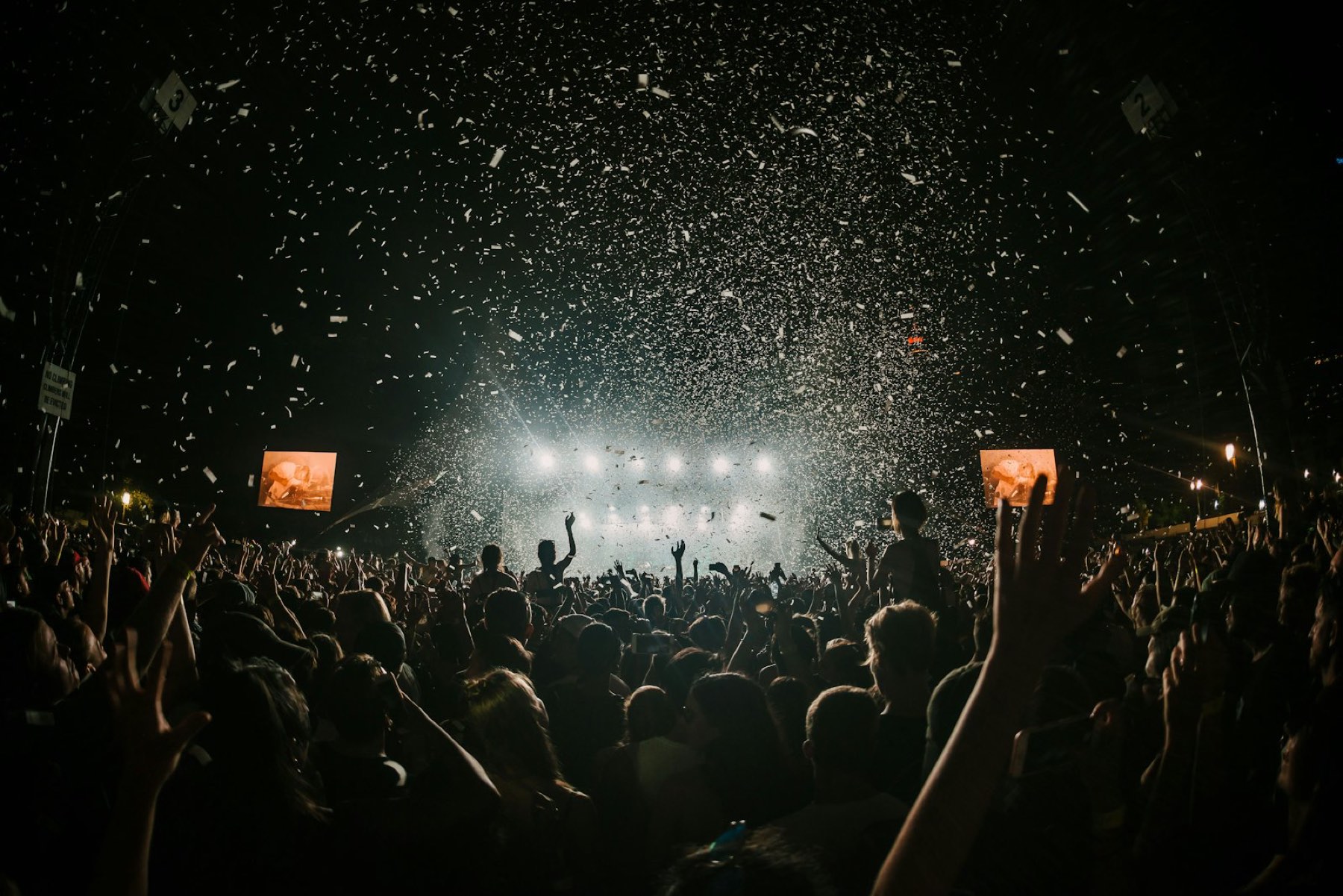 Festival crowd under stage lights and confetti